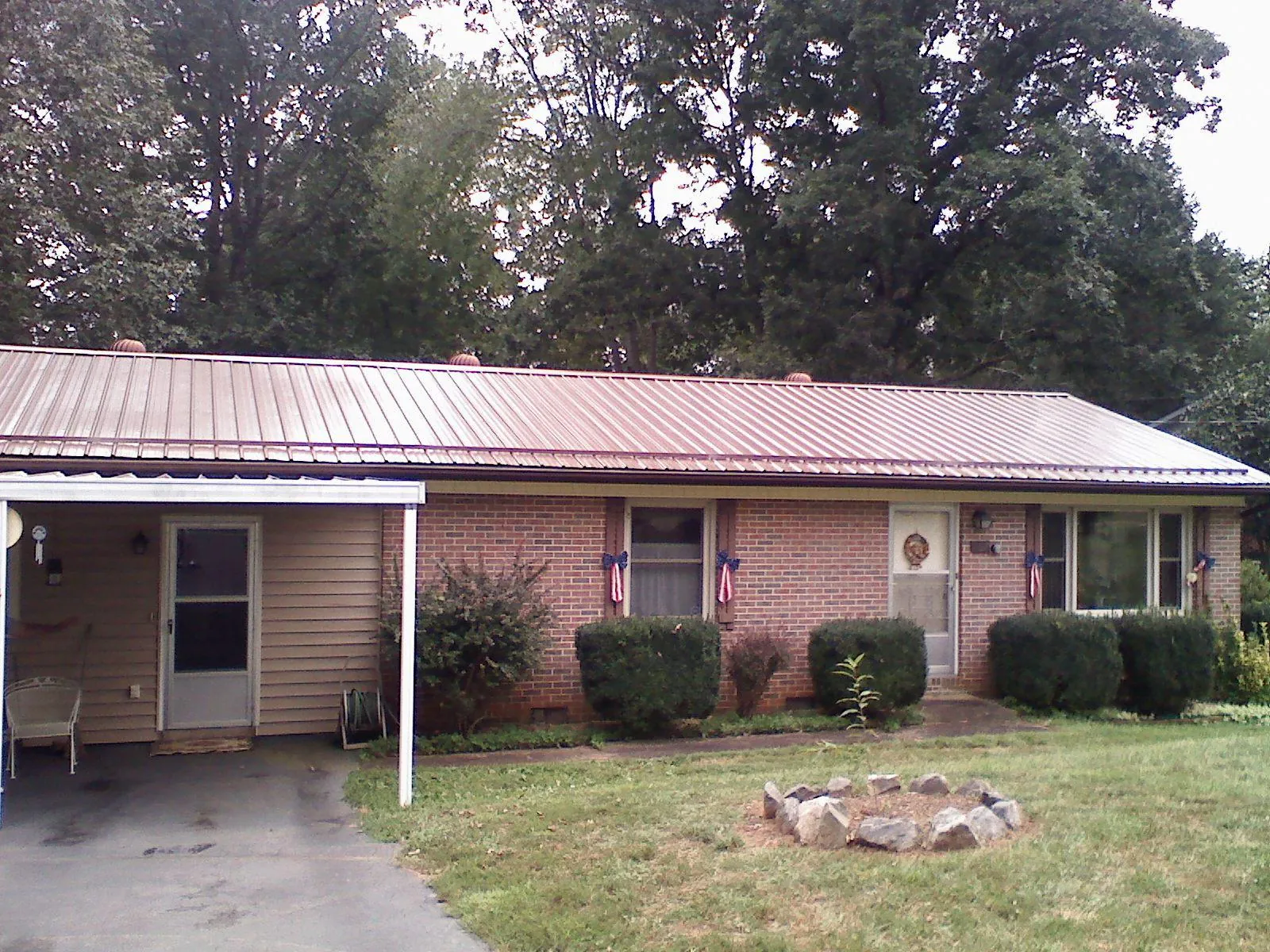 Bronze metal roof and carport on a brick ranch home — Roof Repair work by our crew in Bellville